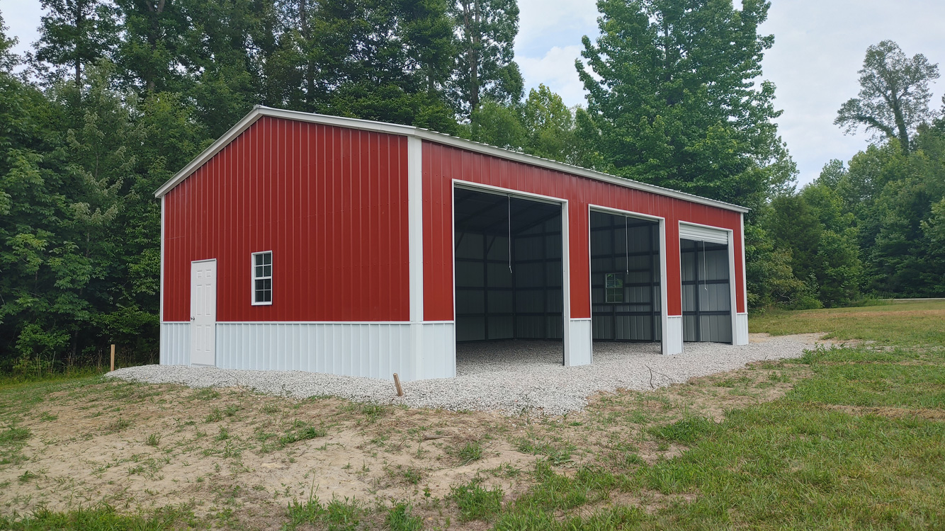 26' wide, 40' long, 12' tall metal garage with vertical metal roof and vertical metal siding, anchored to gravel pad